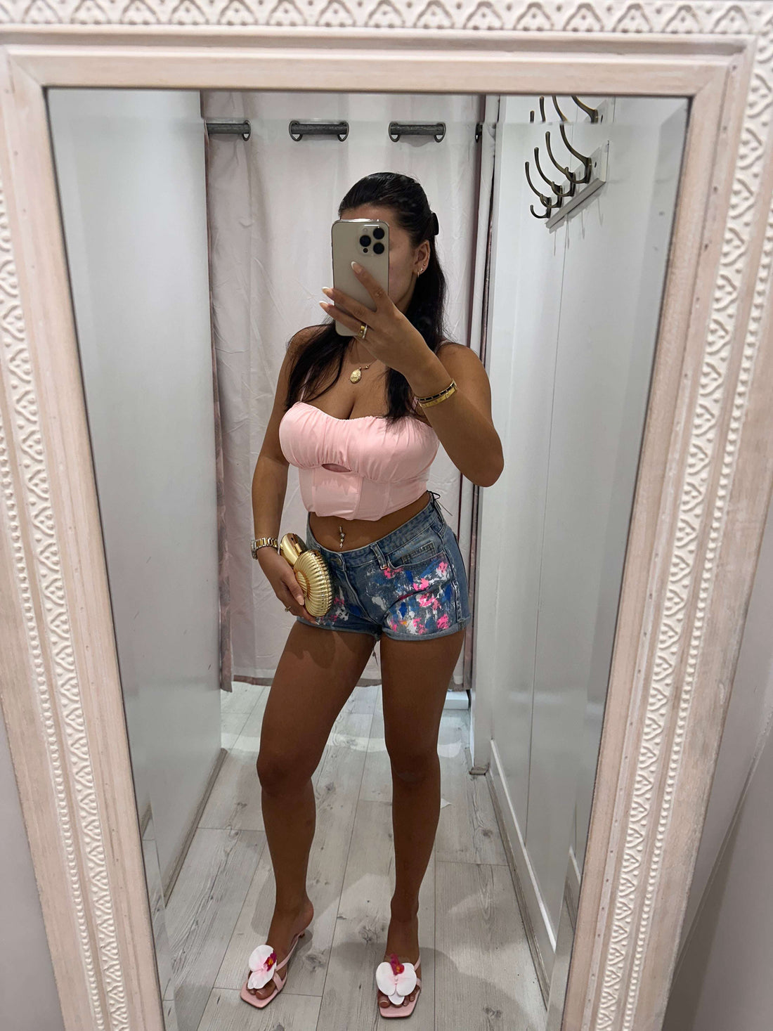 Woman wearing ANGEL Painted Denim Shorts with floral design on a sunny day
