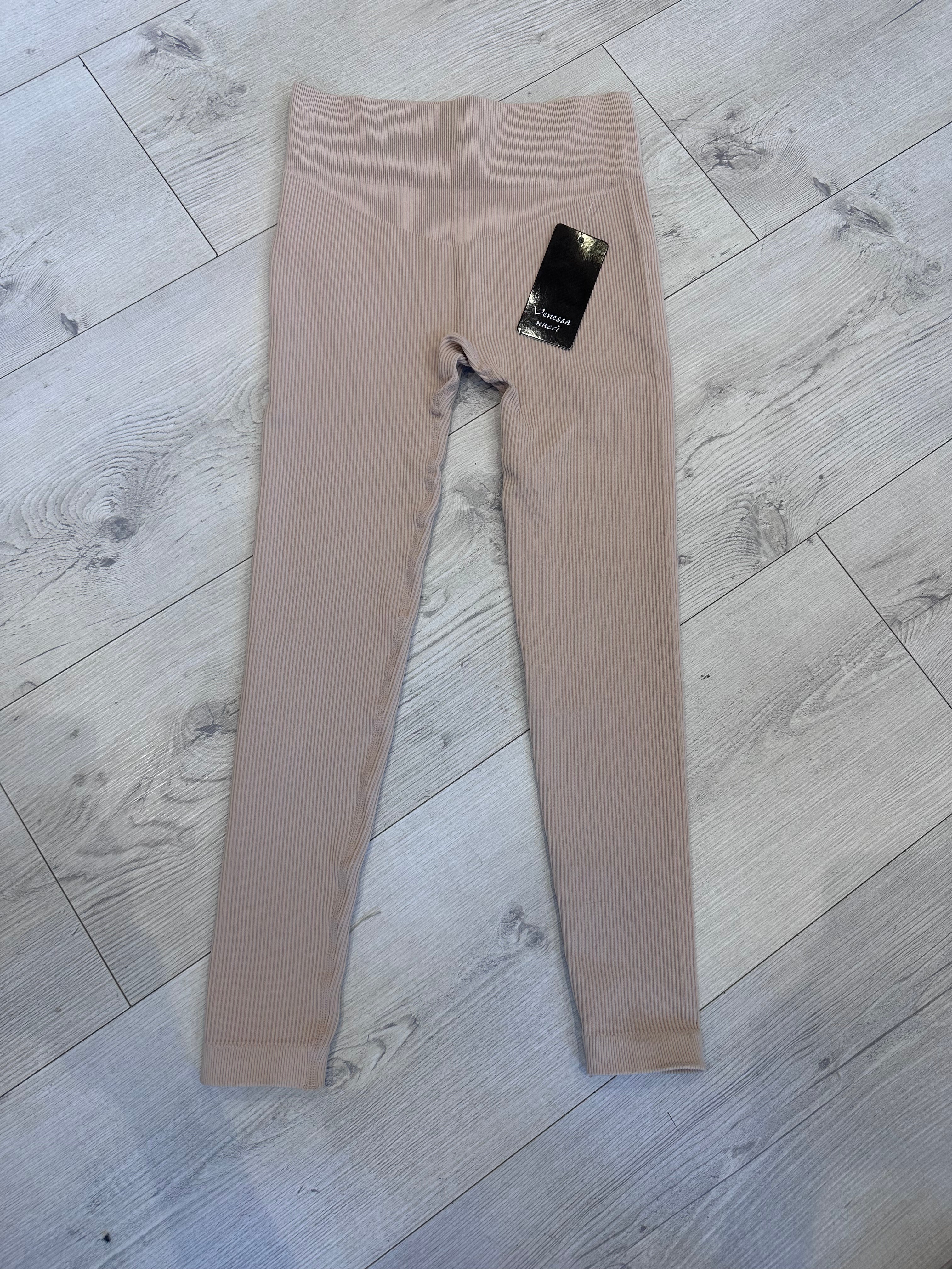 Beige ribbed seamless high-waist leggings for women displayed flat on light wood flooring, featuring a V-contour waistband and soft stretch fabric