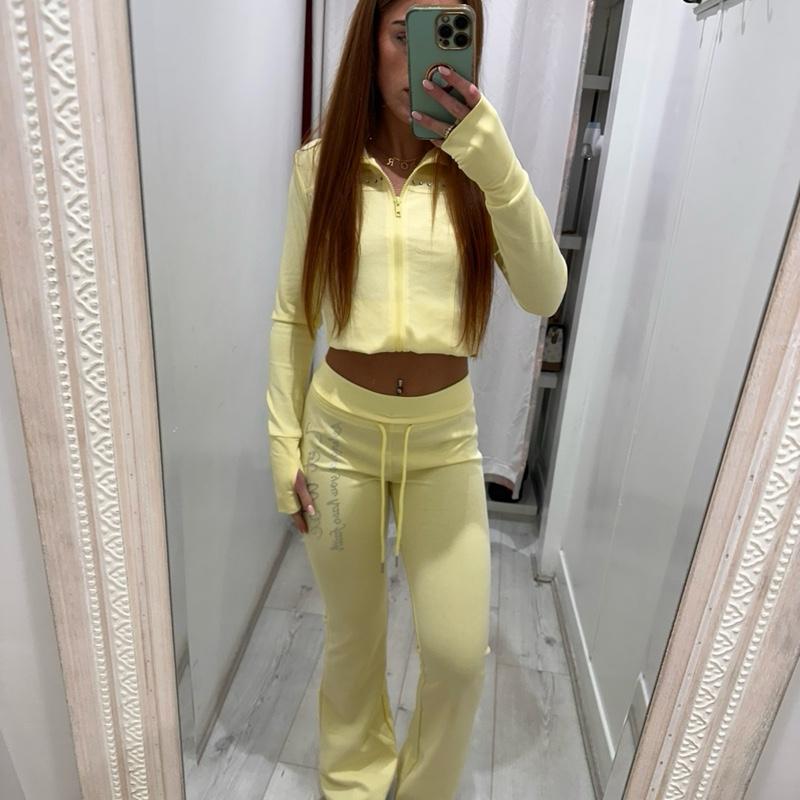 Woman wearing PIXIE Tracksuit Flares with zip-up hoodie and flared joggers in casual setting