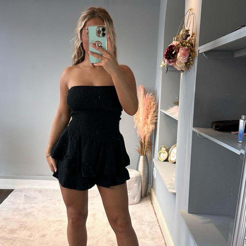 Woman wearing Lola Cheesecloth Summer mini playsuit with frilly shorts and bandeau top outdoors
