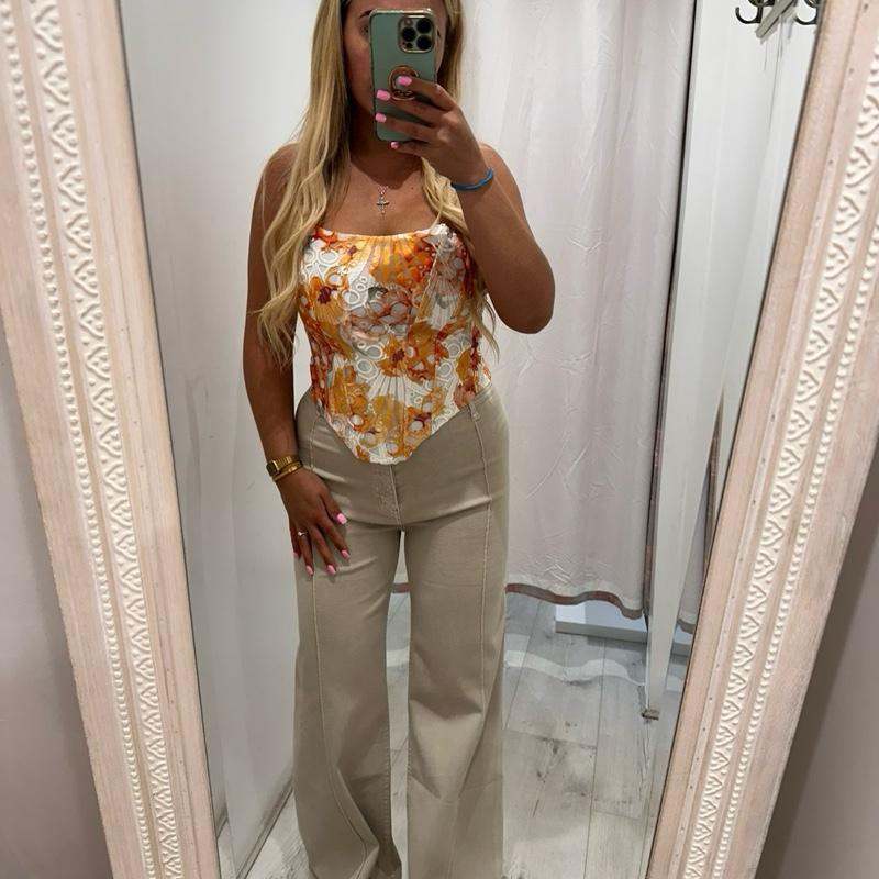 Woman wearing ADA beige jeans with stylish flared design and comfortable fit